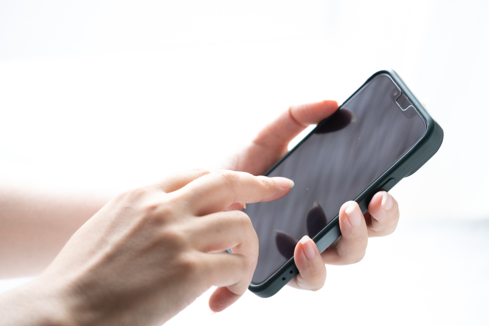 スマートフォンを操作する手元