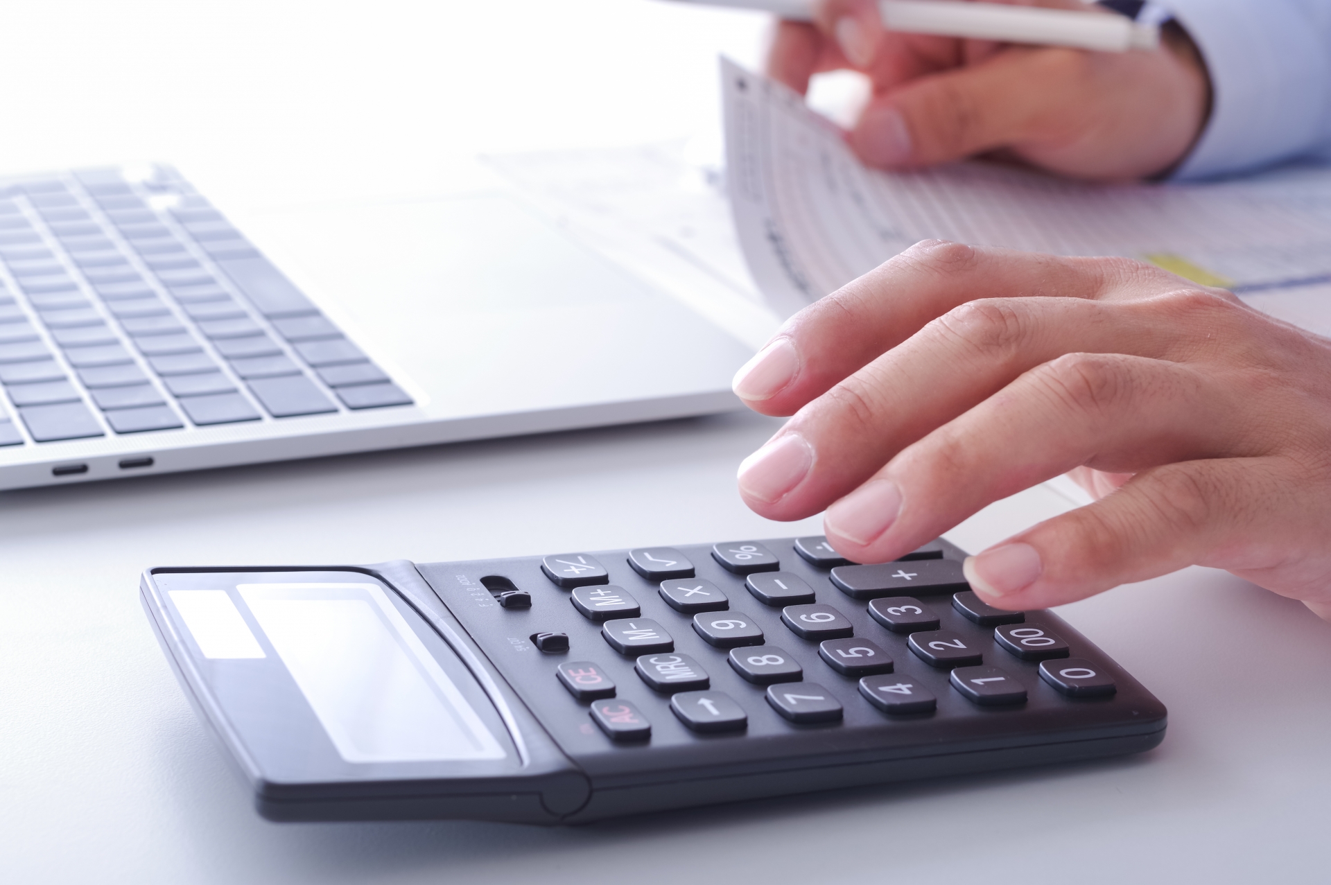 電卓とノートPCで料金計算する手元