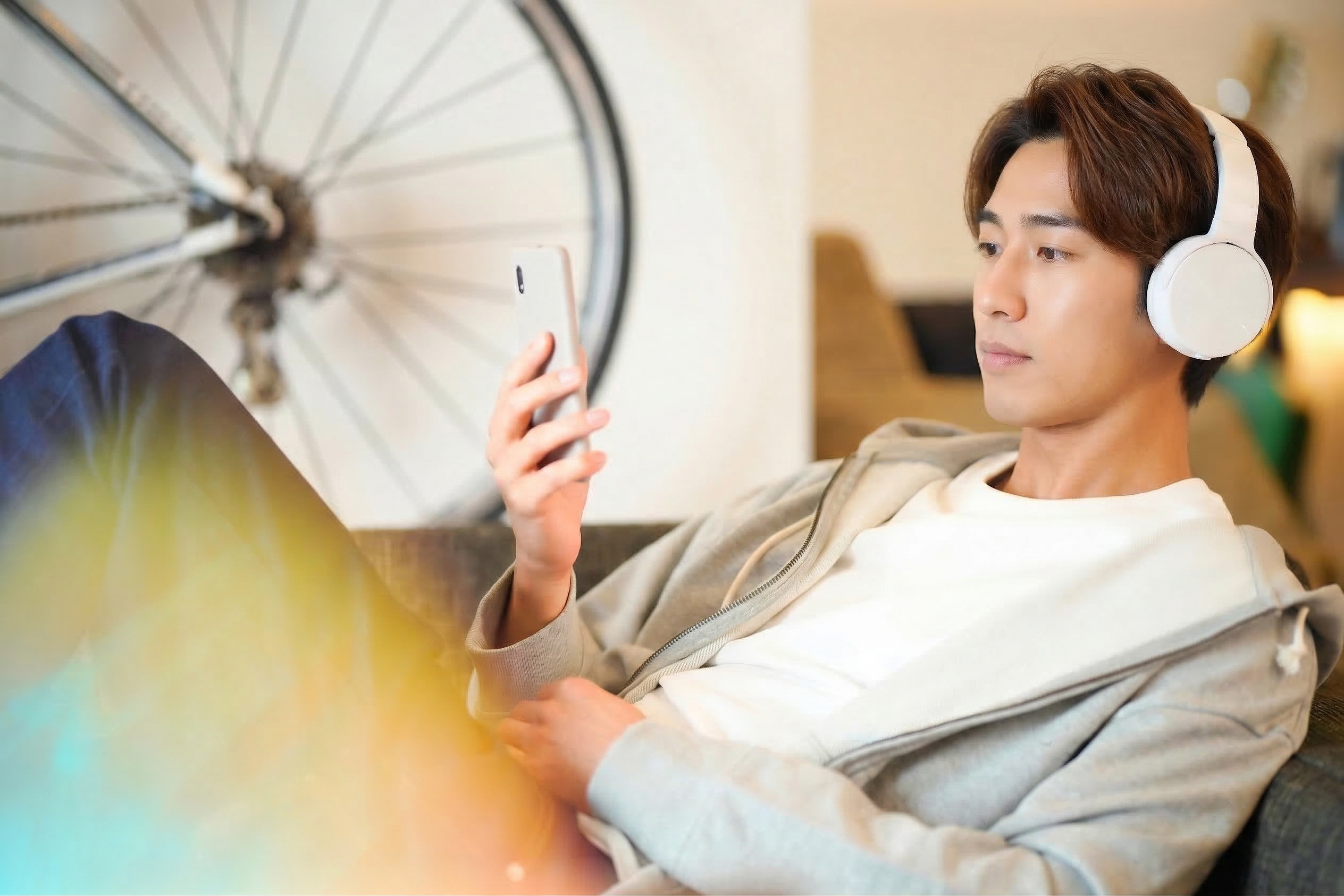 ソファでスマホを見る男性