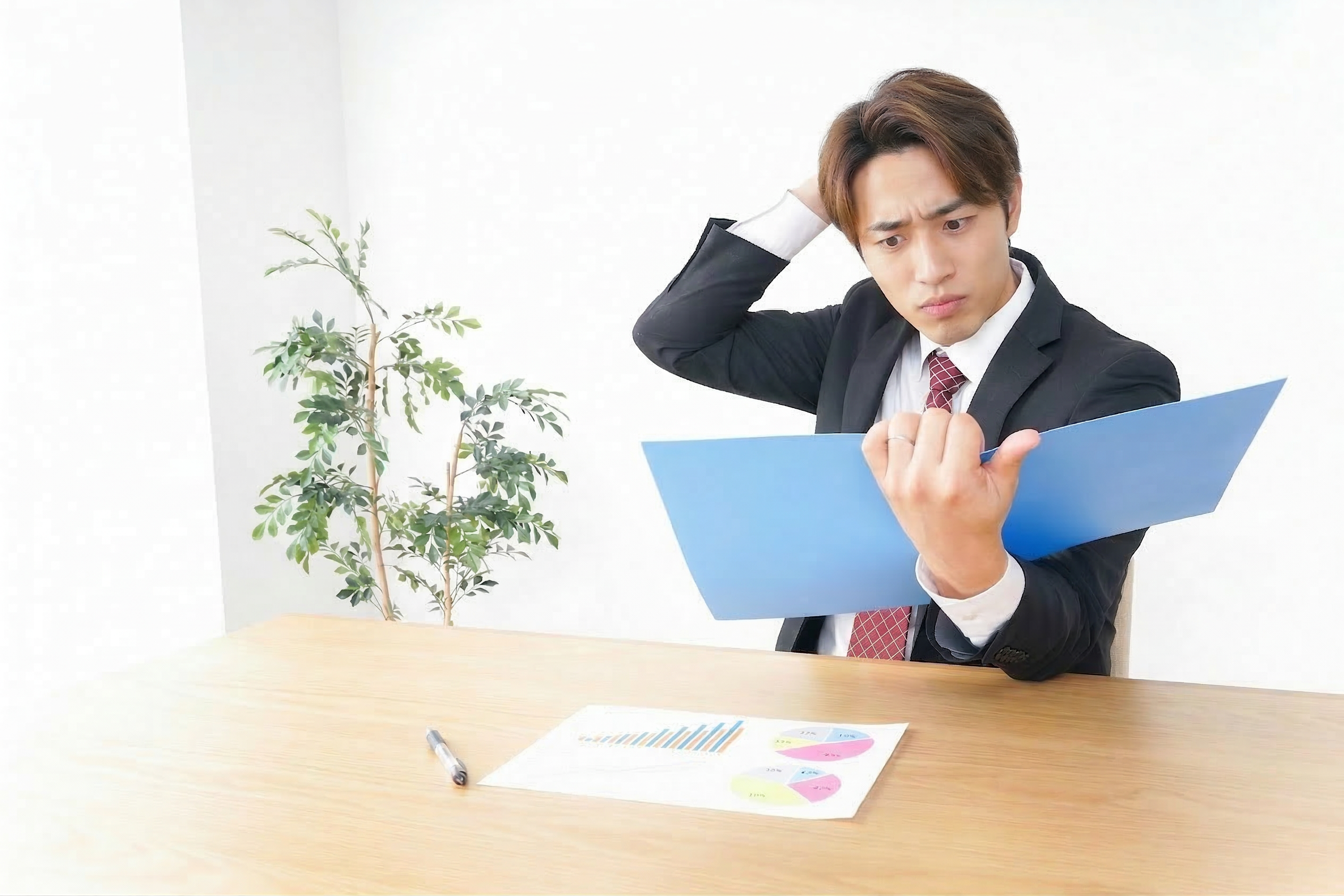書類を見て悩むスーツ姿の男性